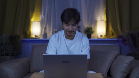 Hombre-Feliz-Usando-Una-Computadora-Portátil-Por-La-Noche.